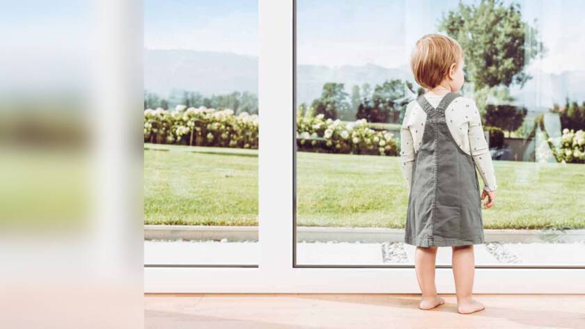 Bambina davanti a una portafinestra affacciata sul giardino