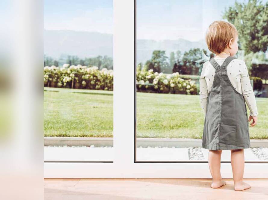 Bambina davanti a una portafinestra affacciata sul giardino