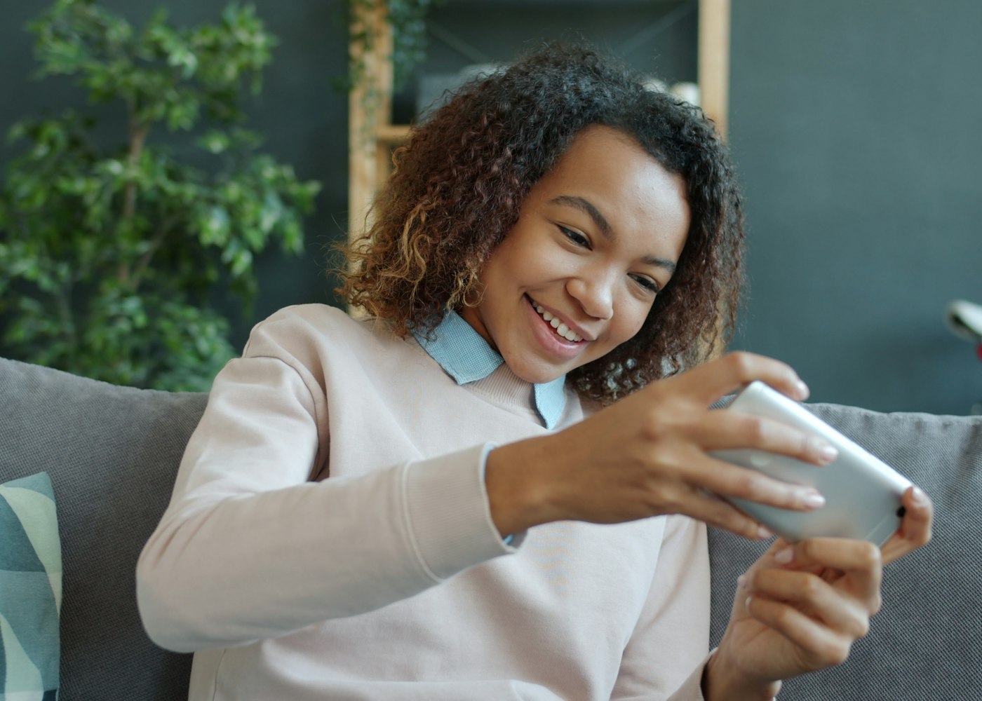 Persona che usa lo smartphone sul divano